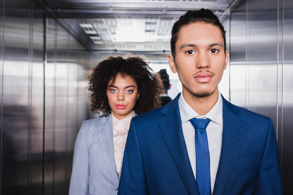 African american businessman and businesswoman standing in elevator - Photo, Image