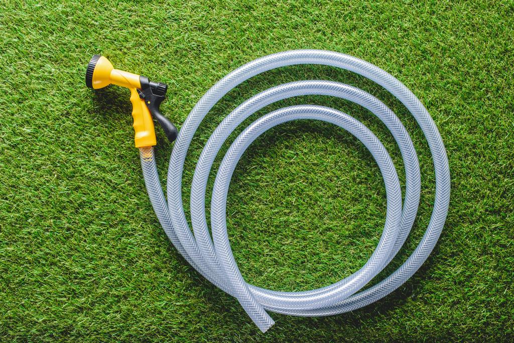 top view of hosepipe on green grass, minimalistic conception  - Photo, Image