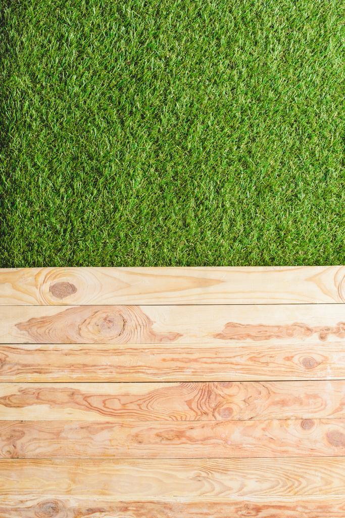 top view of green lawn and wooden planks background  - Photo, Image