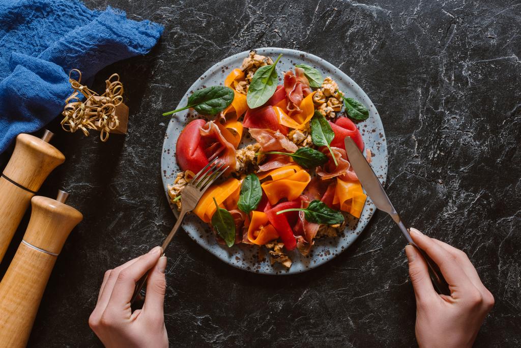 Oříznout záběr člověka jíst lahodný salát s mušlemi, zeleninou a jamon   - Fotografie, Obrázek