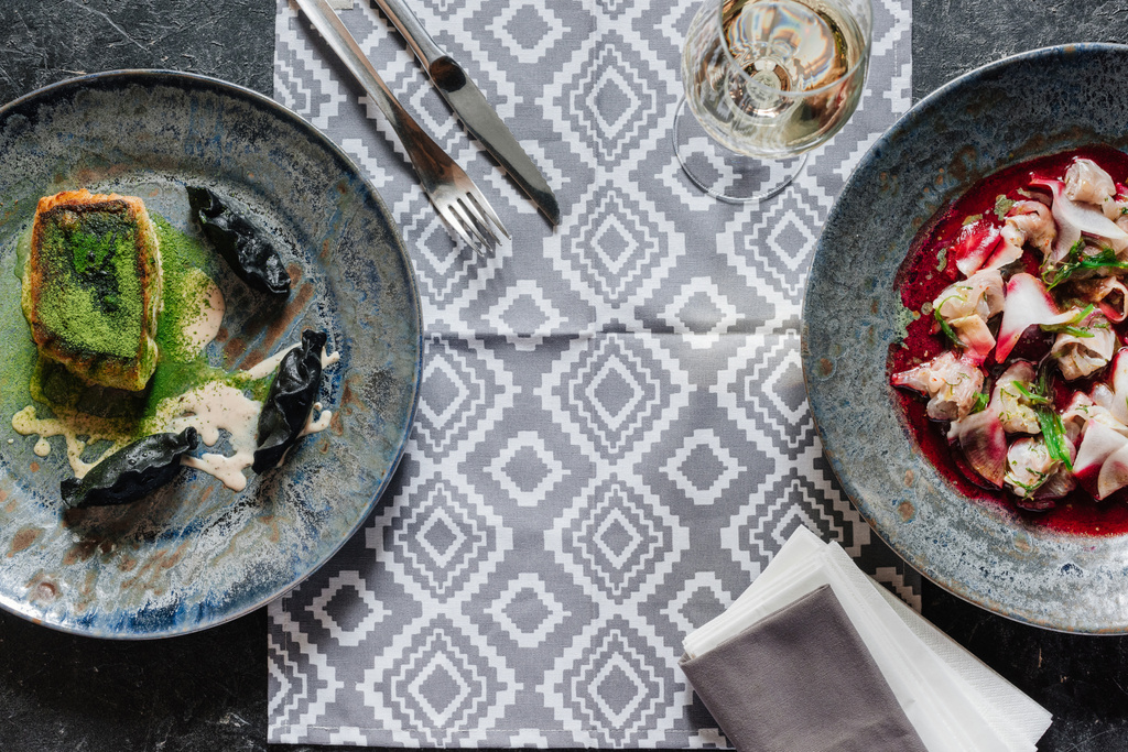 bovenaanzicht van gastronomische Gebakken snoekbaars, ceviche met dorado en glas wijn  - Foto, afbeelding