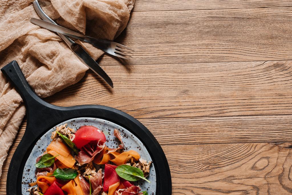 Salat mit Miesmuscheln, Wurzelgemüse und Marmelade auf Holztisch - Foto, Bild