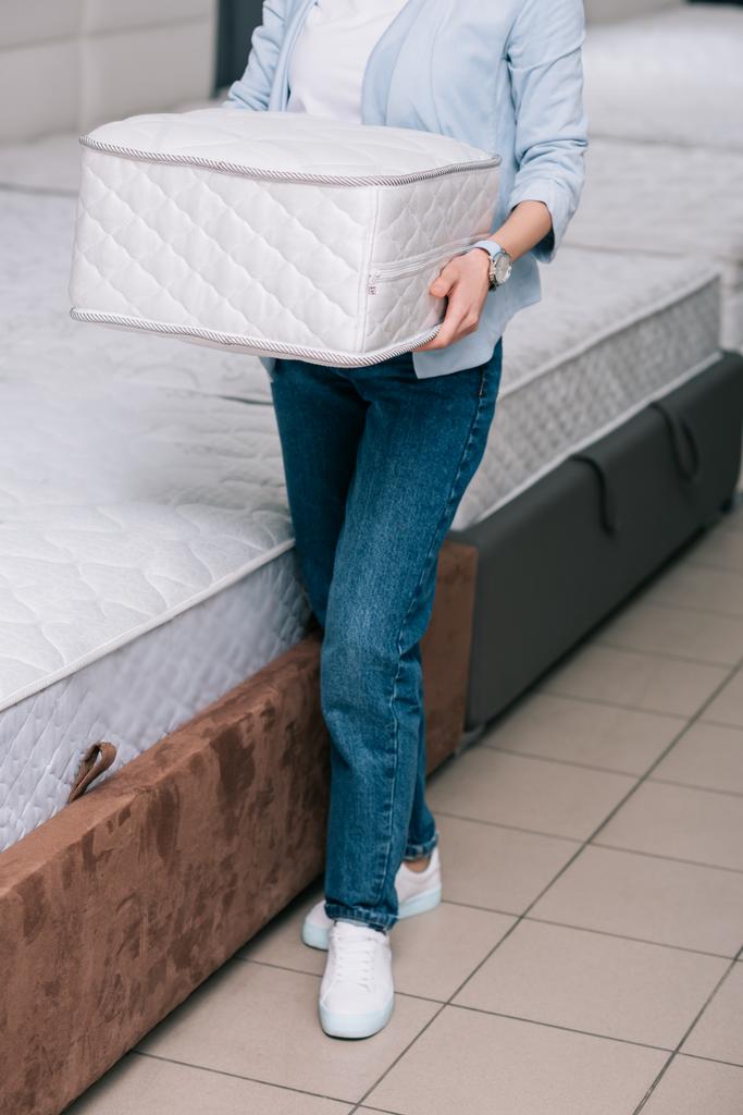 cropped shot of woman with folding mattress in hands in furniture shop - Photo, Image