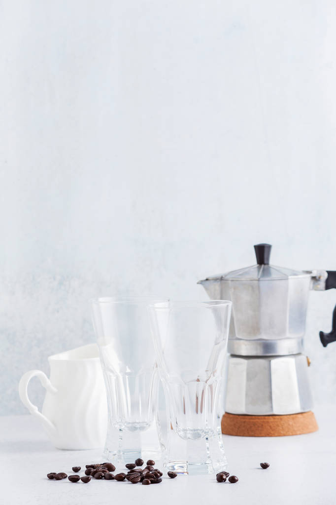 пустые стаканы и кувшин молока с кофейными зёрнами и кофеваркой
  - Фото, изображение