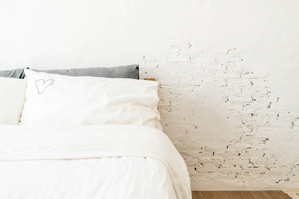 Белая подушка на декоре кровати в доме
  - Фото, изображение