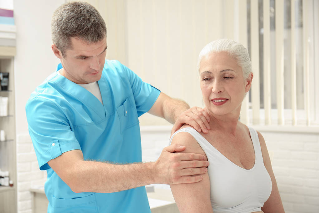Masaż ramion coraz starsza kobieta o gabinet fizykoterapii - Zdjęcie, obraz
