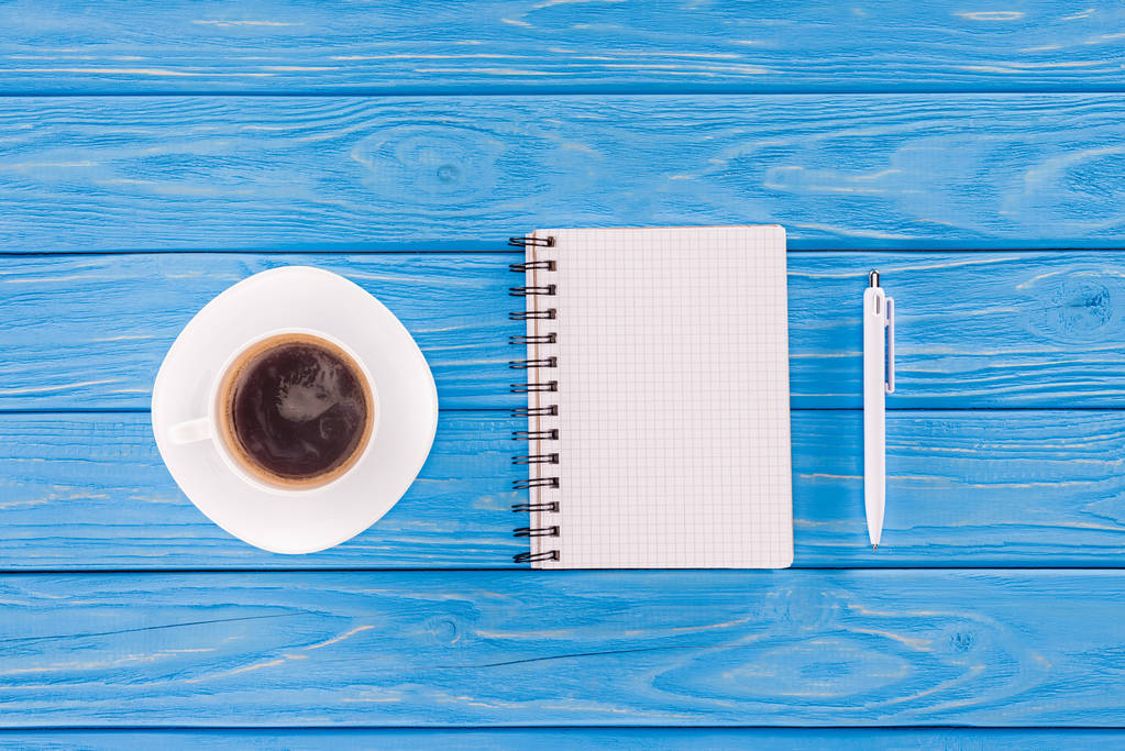 вид зверху порожній підручник, ручка і чашка кави на синіх дерев'яних дошках
 - Фото, зображення