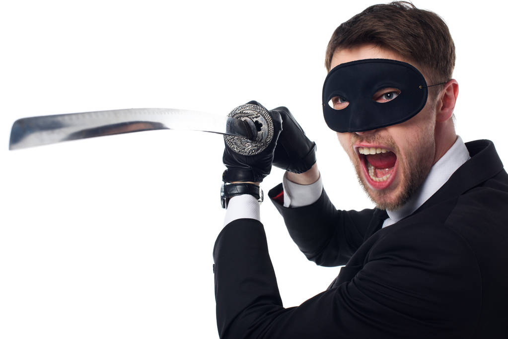 портрет эмоционального шпиона в маске и перчатках с катаной, изолированной на белом
 - Фото, изображение