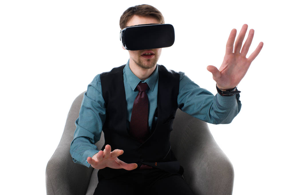 Portret van agent in virtuele werkelijkheid hoofdtelefoon zitten in een leunstoel geïsoleerd op wit - Foto, afbeelding