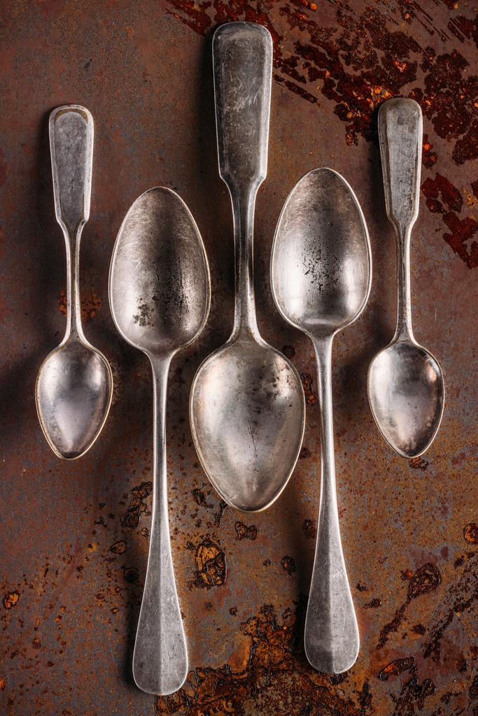 Conjunto de cucharas viejas sobre mesa oxidada vintage
 - Foto, imagen