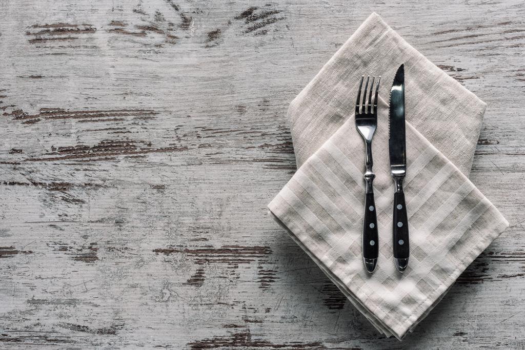 木製のテーブルにナプキンにナイフで金属フォーク - 写真・画像