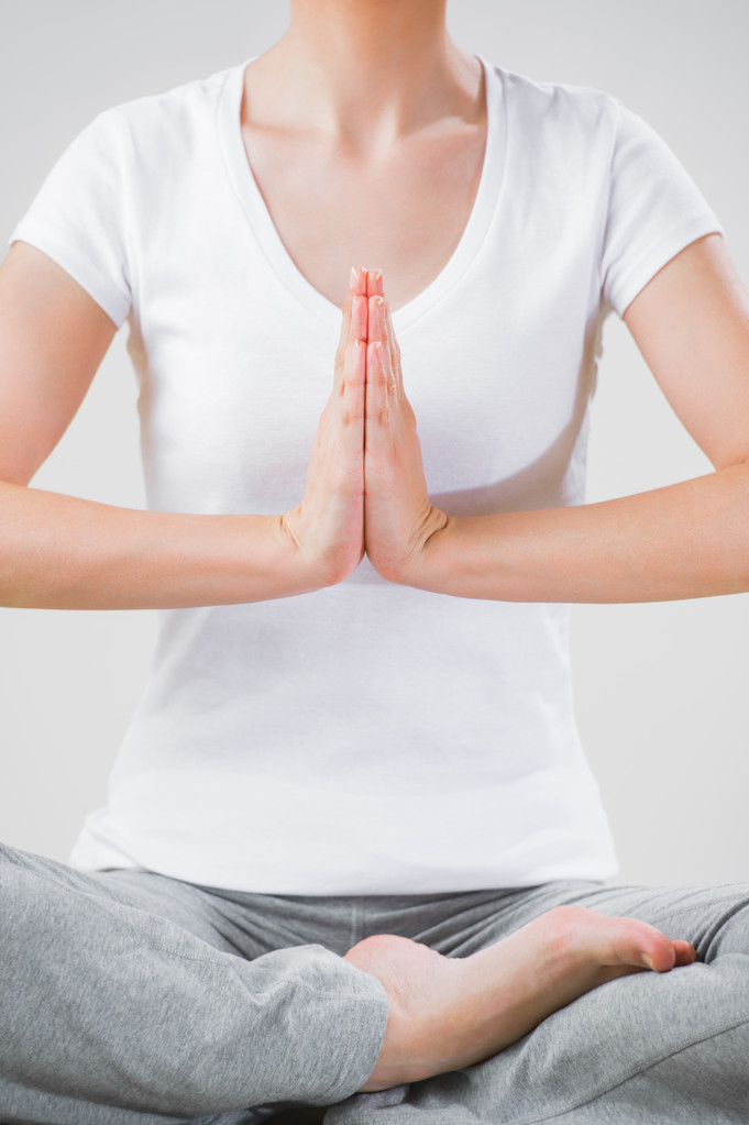 A young woman sitting in the lotus position while meditating - Photo, Image