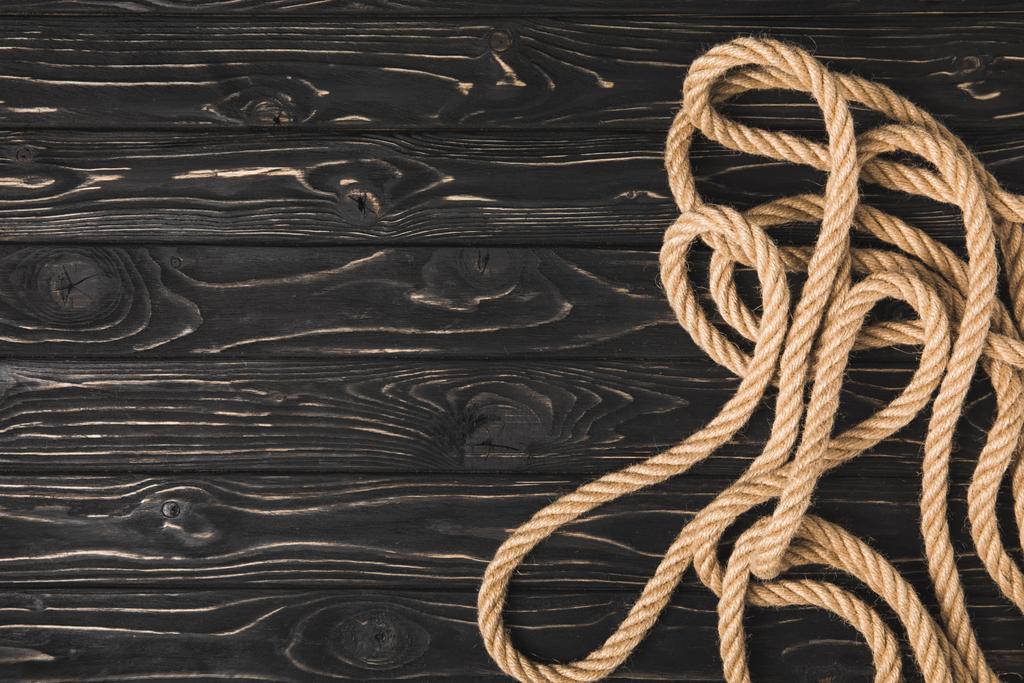 вид зверху на коричневу морську мотузку на темній дерев'яній поверхні
  - Фото, зображення