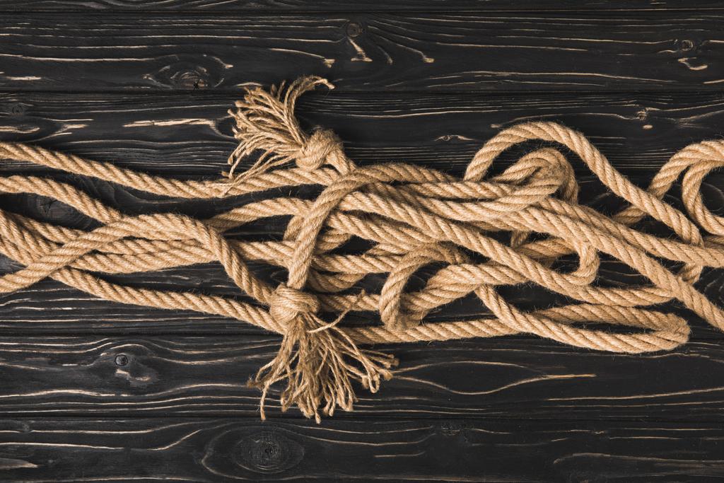 暗い木製の板に茶色の航海ロープの上から見る - 写真・画像