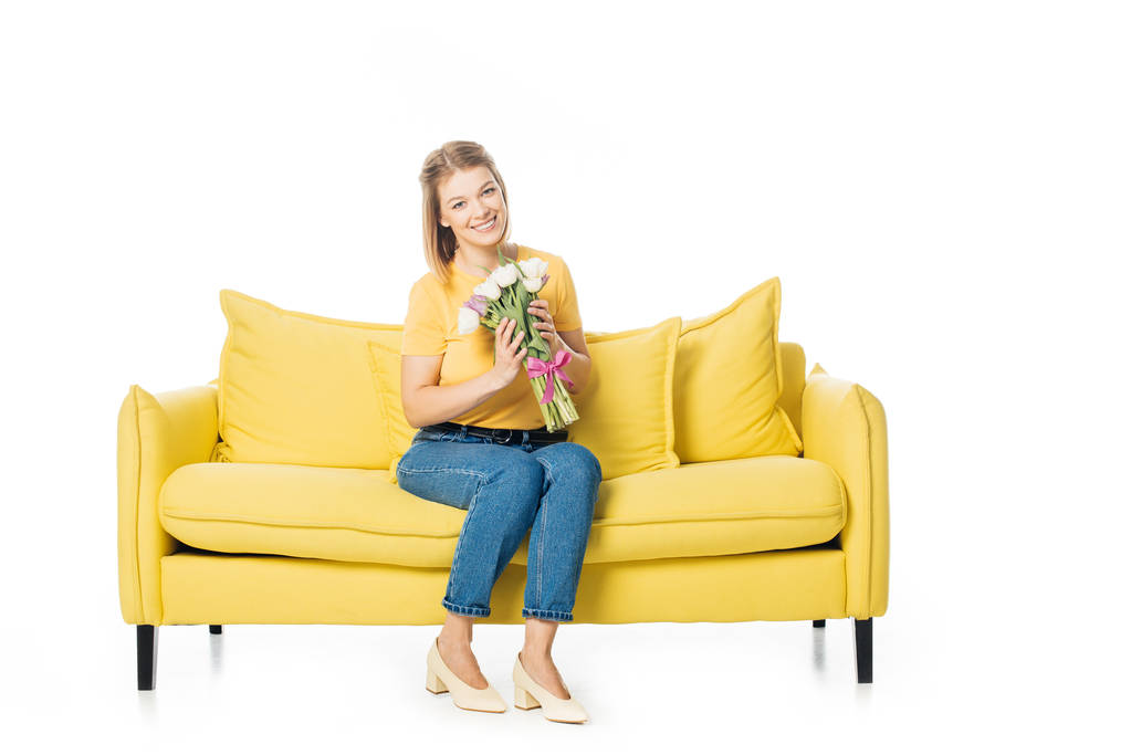 kaunis hymyilevä nainen kimppu tulppaanit istuu keltainen sohva eristetty valkoinen
 - Valokuva, kuva