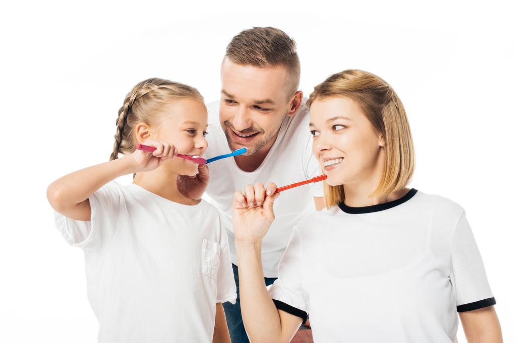 πορτρέτο της οικογένειας με παρόμοια ρούχα βουρτσίζετε τα δόντια απομονώνονται σε λευκό - Φωτογραφία, εικόνα