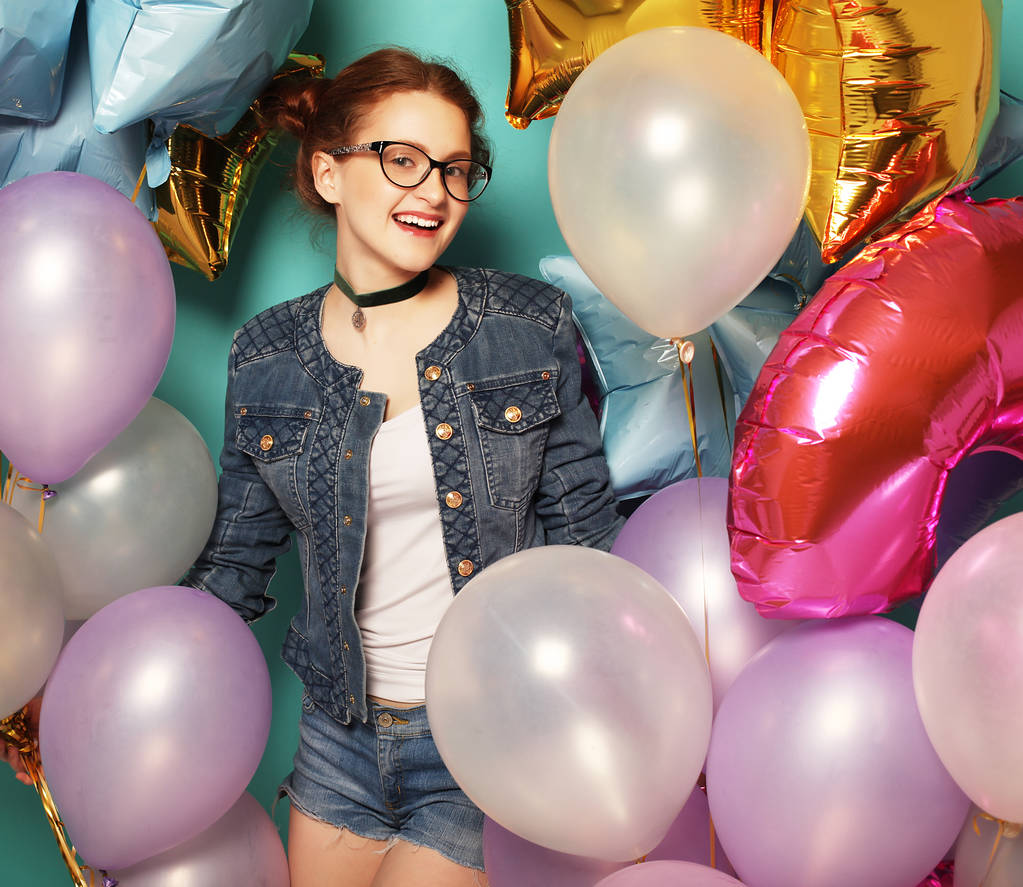 Retrato de menina ruiva à espera de festa. Linda mulher jovem alegre se divertindo com balões brilhantes, sobre fundo azul. Conceito de estilo de vida
. - Foto, Imagem