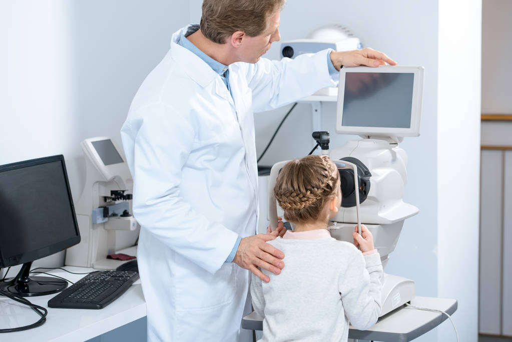 Augenarzt untersucht das Sehvermögen präpubertärer Kinder in der Klinik - Foto, Bild
