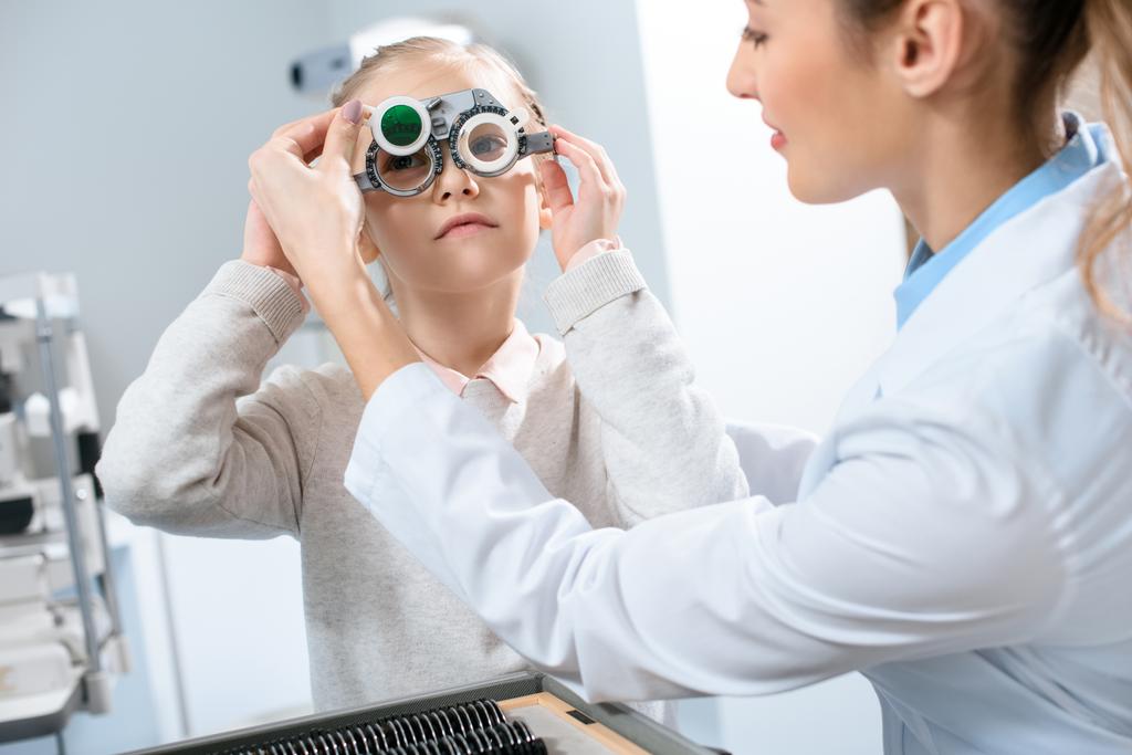 θηλυκό ΟΦΘΑΛΜΙΑΤΡΟΣ εξέταση παιδί μάτια με δοκιμή πλαίσιο και φακοί - Φωτογραφία, εικόνα