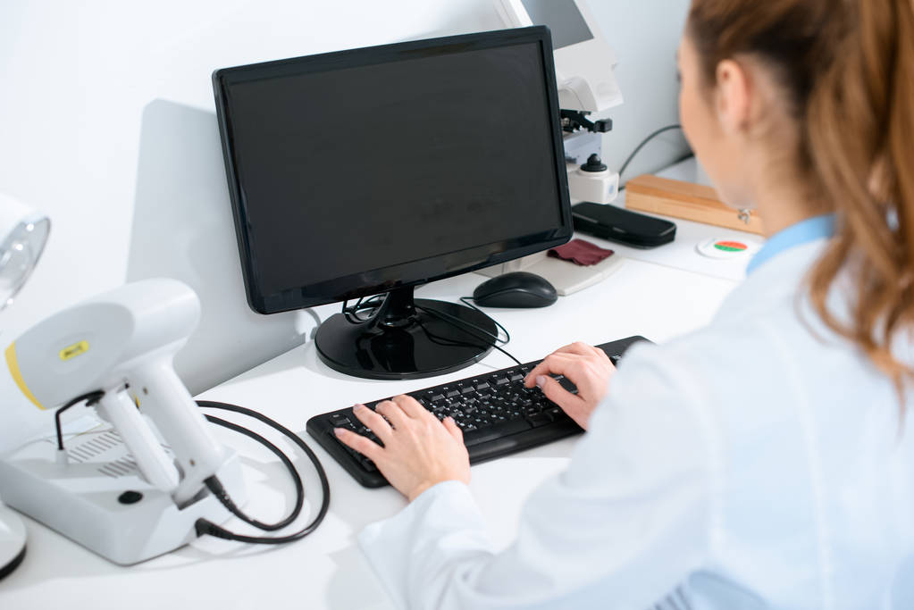 επιλεκτική εστίαση του γυναικείου ΟΦΘΑΛΜΙΑΤΡΟΣ χρήση υπολογιστή στην κλινική - Φωτογραφία, εικόνα