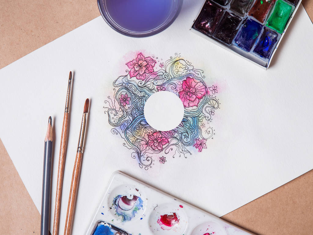 Sheet of watercolor painting on the table. Abstract floral with white circle in the center. - Photo, Image
