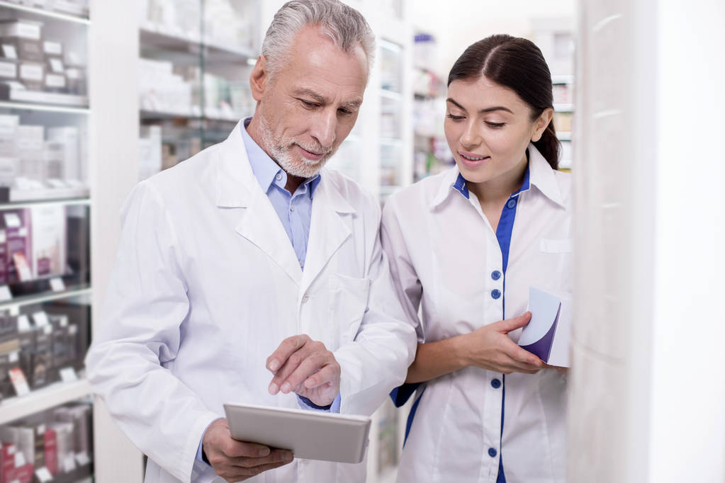 Experienced male pharmacist giving advising colleague - Photo, Image