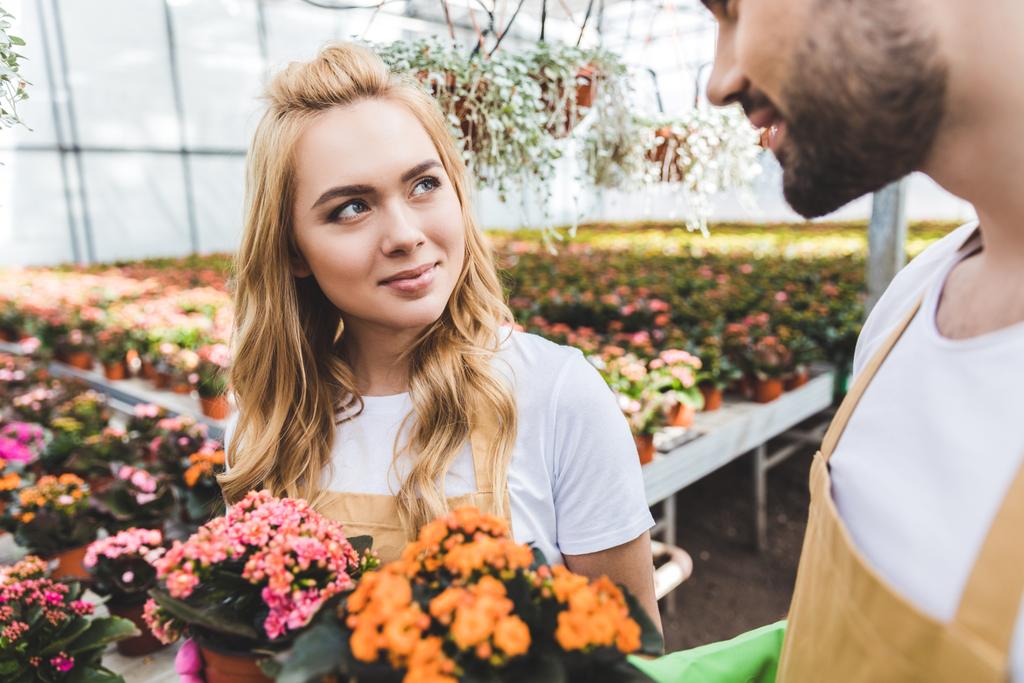 Nuori mies ja nainen puutarhurit tilalla ruukut kukkia
 - Valokuva, kuva