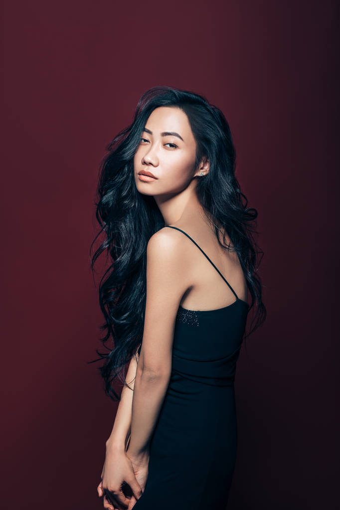 Studio kahverengi zemin üzerinde poz siyah elbiseli güzel Asyalı kadın. Güzel moda model portre - Fotoğraf, Görsel