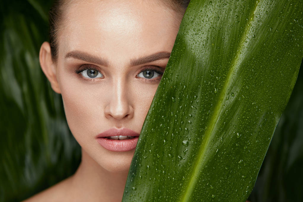 Szépség nő arca, zöld növény, és az egészséges bőr - Fotó, kép