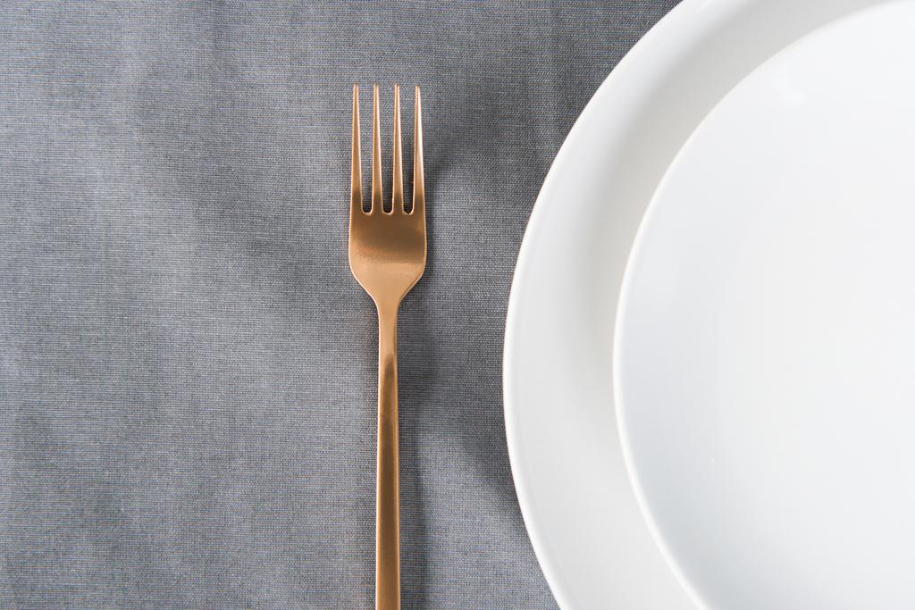top view of arranged tarnished old fashioned fork and empty plates on tabletop - Photo, Image