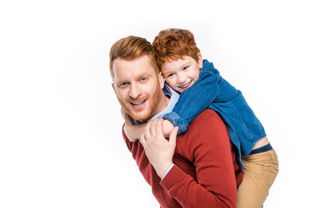 alegre pelirroja padre e hijo abrazando y sonriendo a la cámara aislado en blanco
 - Foto, imagen