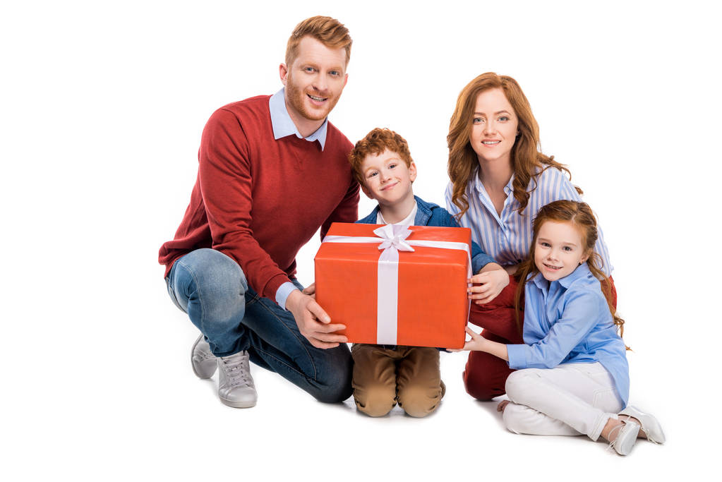 onnellinen punapää perhe tilalla iso lahjapakkaus ja hymyilee kameran eristetty valkoinen
 - Valokuva, kuva