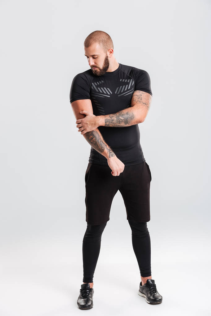 Retrato completo de homem bem construído em sportswear preto fazendo
 - Foto, Imagem