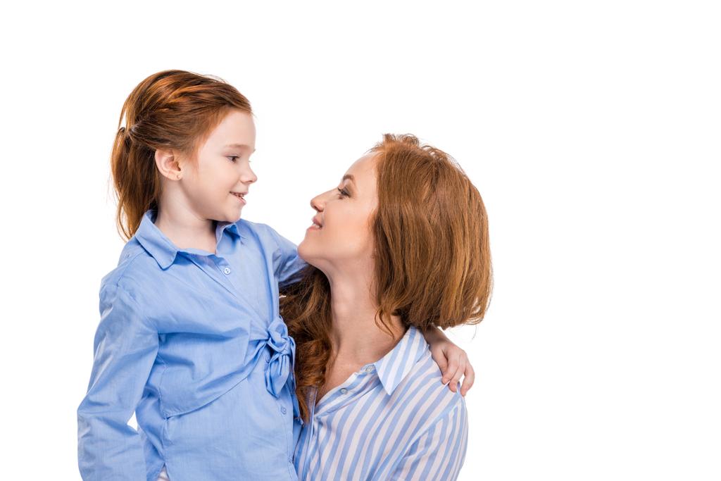 piękne redhead matka i córka uśmiechający się nawzajem na białym tle - Zdjęcie, obraz