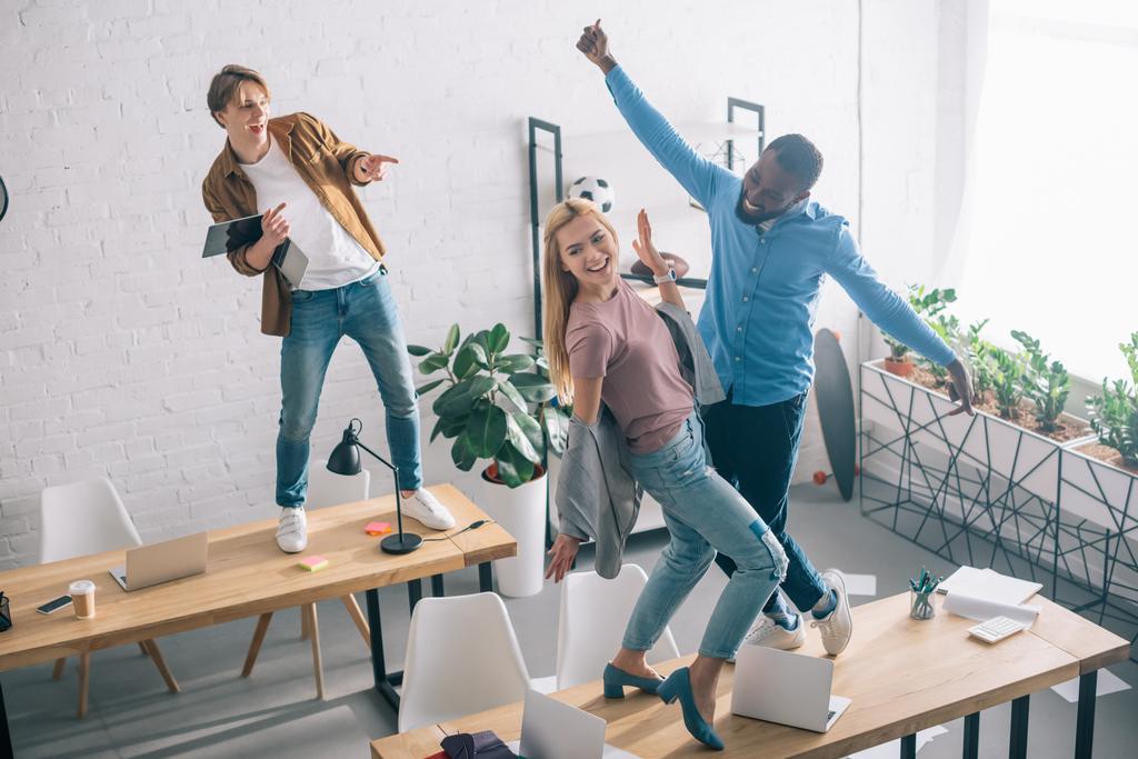 високий кут зору щасливих багатоетнічних бізнес-колег танцює і розважається в сучасному офісі
  - Фото, зображення