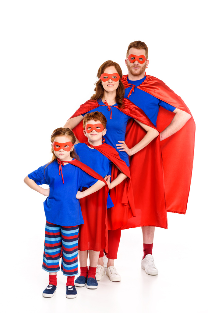 super familia en máscaras y capas de pie con las manos en la cintura y sonriendo a la cámara aislada en blanco
 - Foto, imagen