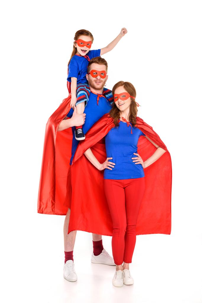 Super family with one child in masks and cloaks smiling at camera isolated on white
 - Фото, изображение