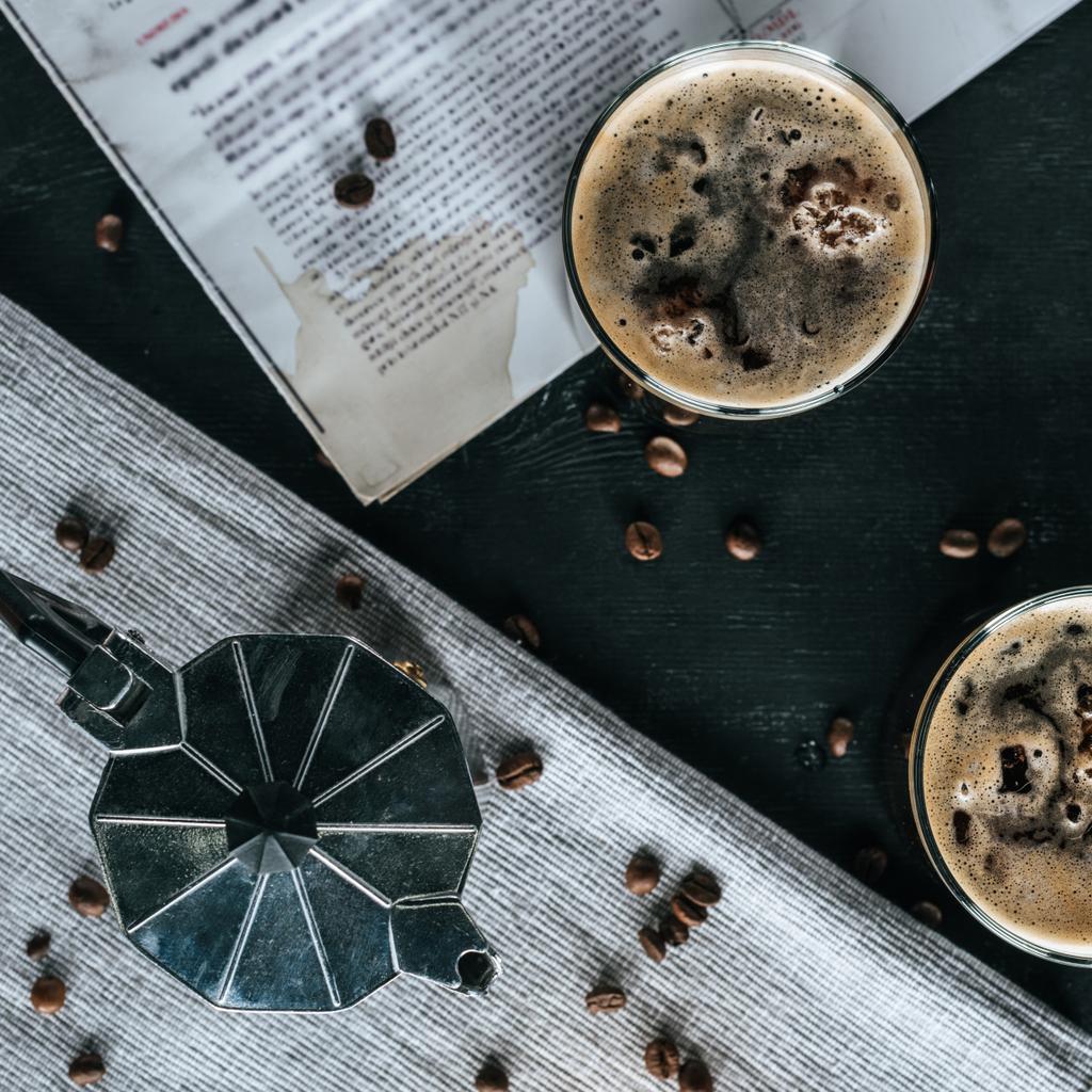 tumbado plano con cafetera, periódico y vasos de café elaborado en frío sobre una mesa negra
 - Foto, Imagen