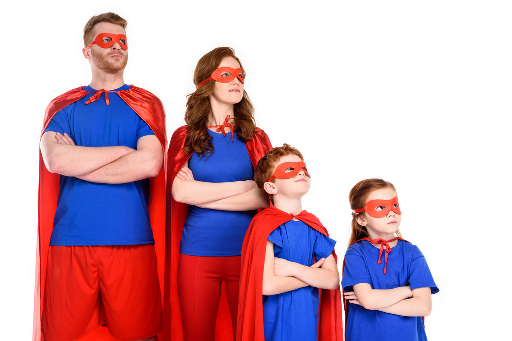 famille confiante de super-héros en costumes debout avec les bras croisés et regardant loin isolé sur blanc
 - Photo, image