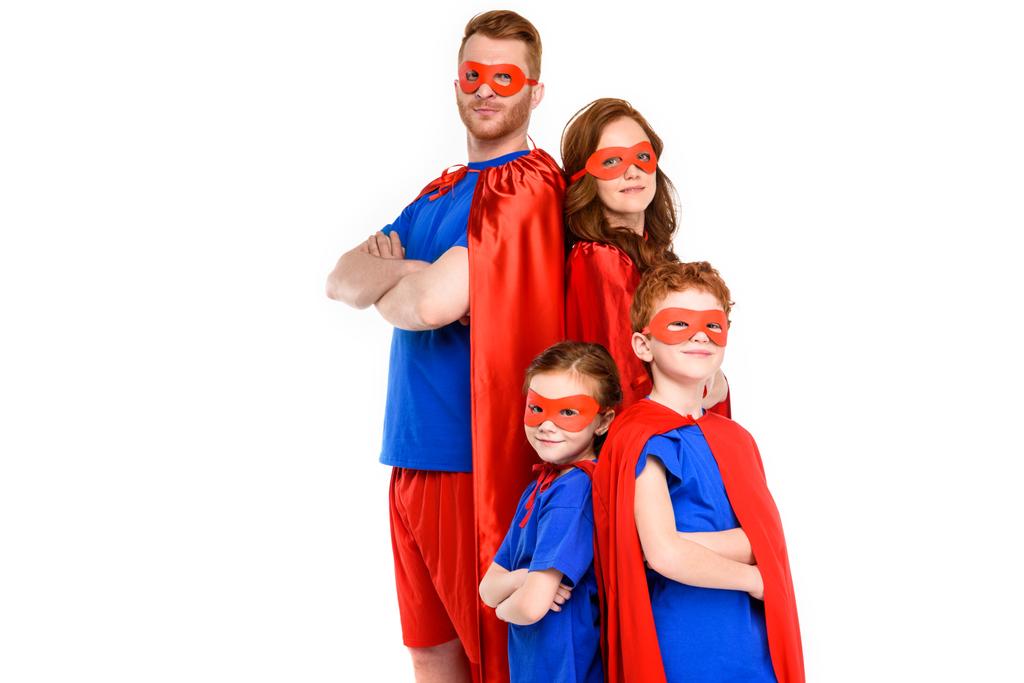 組んだ腕の側に立って、白で隔離カメラ目線のスーパー ヒーロー衣装で家族 - 写真・画像