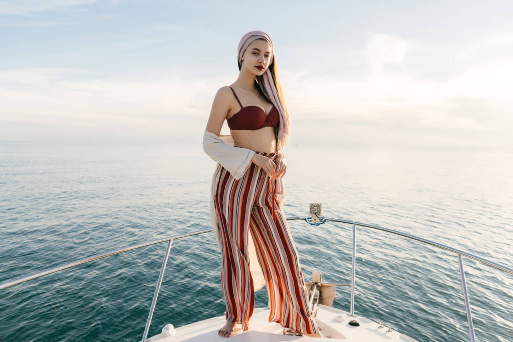 confident luxurious rich girl stands on her white yacht, resting and relaxing, sea voyage - Photo, Image