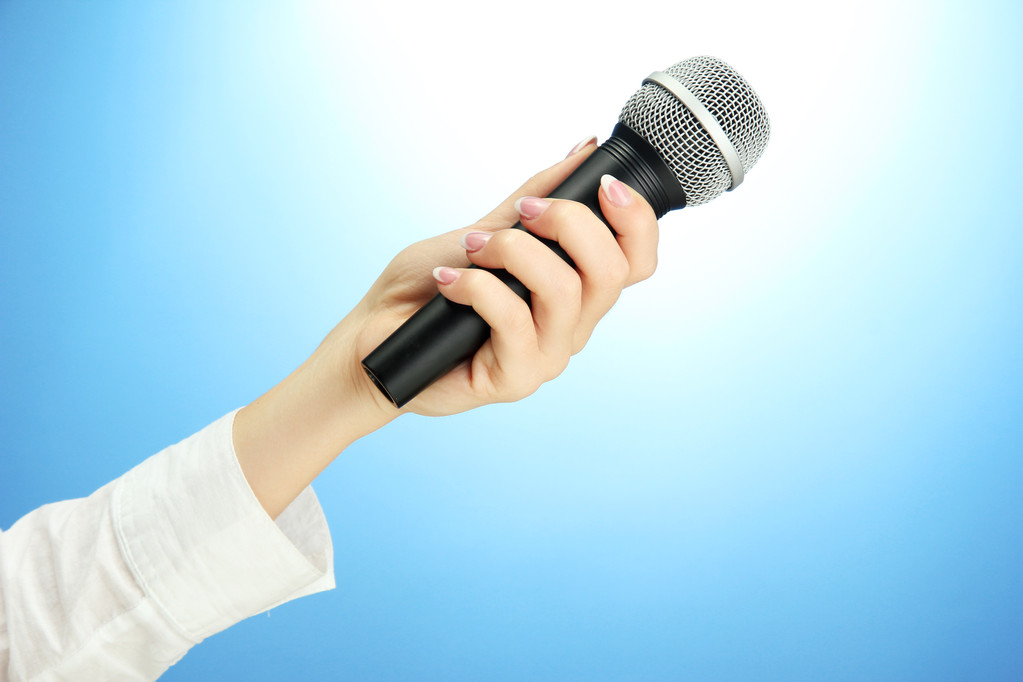 mano femminile con microfono, su sfondo blu
 - Foto, immagini