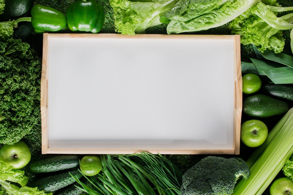 vista elevada da bandeja em branco entre vegetais verdes, conceito de alimentação saudável
 - Foto, Imagem