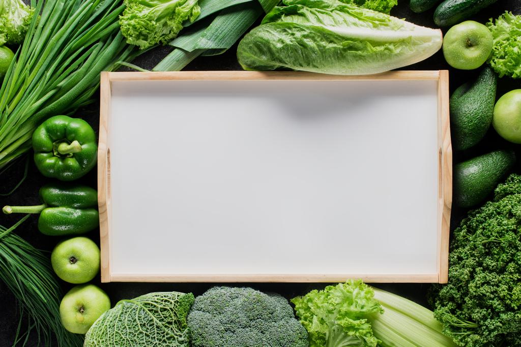 вид сверху на чистый поднос между зелеными овощами, концепция здорового питания
 - Фото, изображение