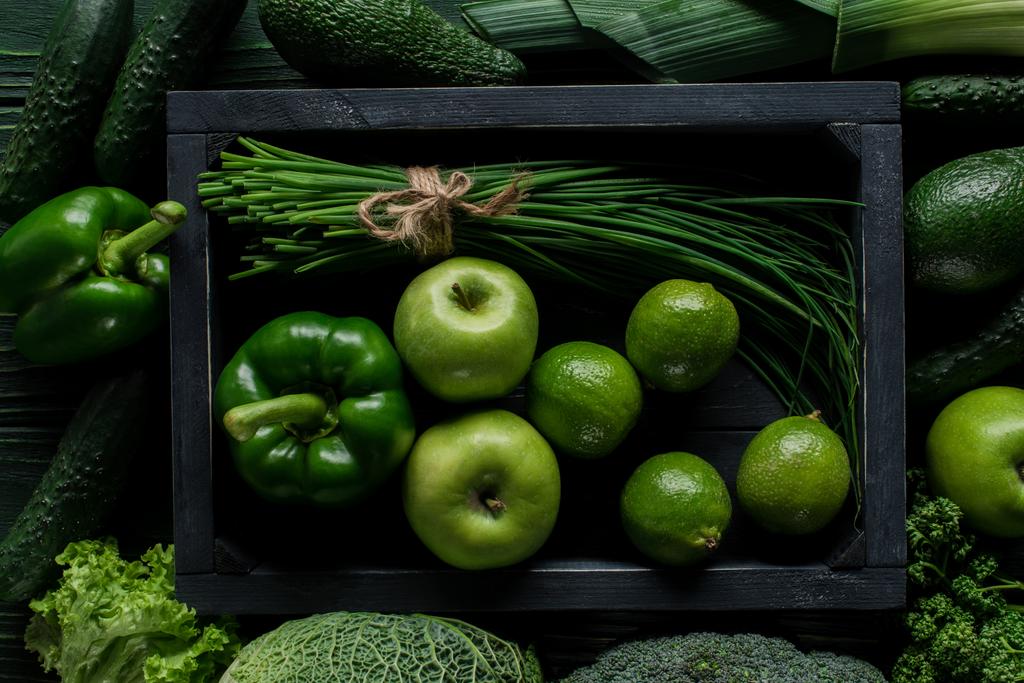 pohled shora zelené zeleniny a ovoce v dřevěné krabičce na stole, zdravé stravovací koncept - Fotografie, Obrázek