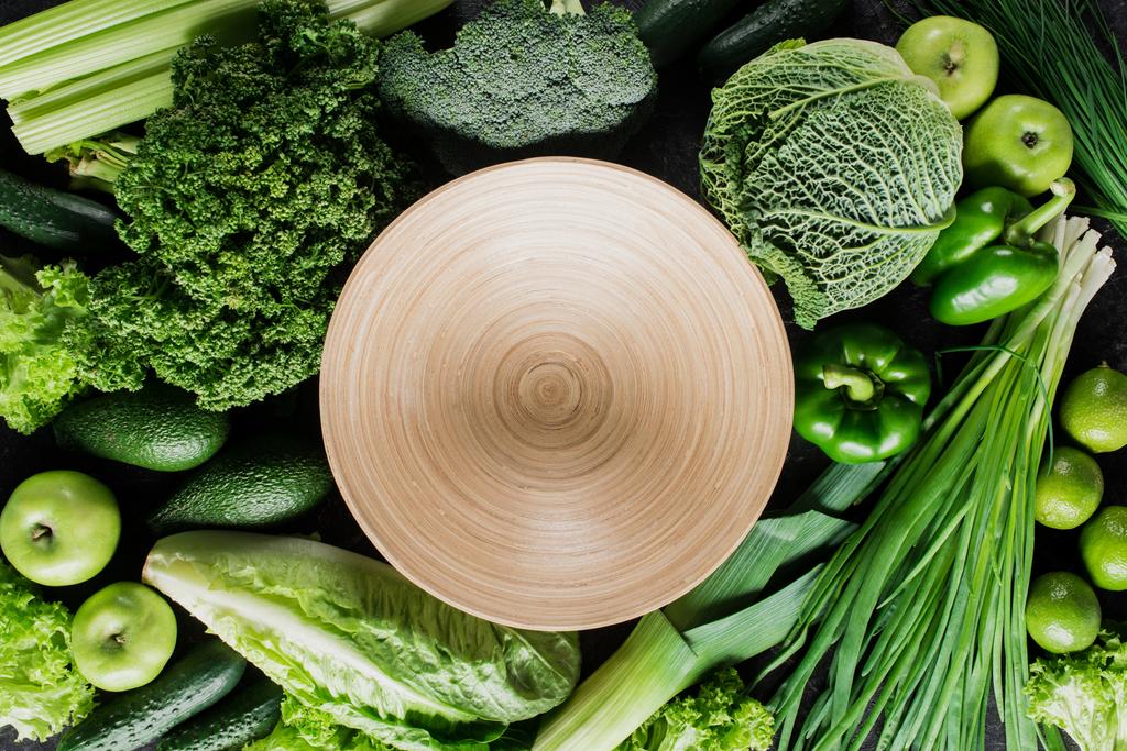 top view of cutting board between green vegetables, healthy eating concept - Photo, Image