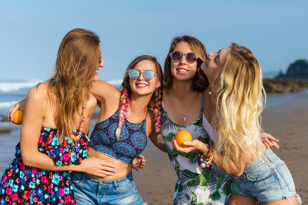 группа счастливых молодых женщин, обнимающихся на пляже
 - Фото, изображение
