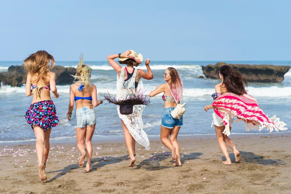 Rückansicht einer Gruppe von Frauen, die auf See laufen - Foto, Bild