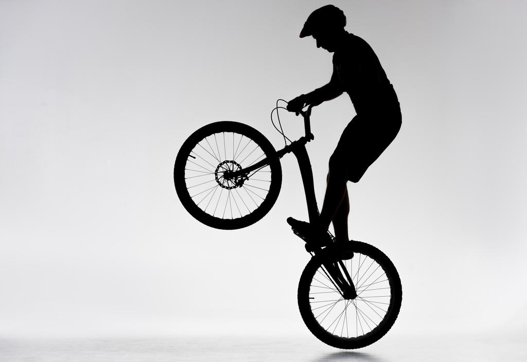 silueta zkušební biker provádí bunny hop na bílém - Fotografie, Obrázek