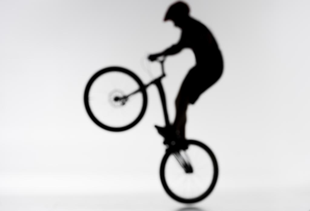plan flou de la silhouette du motard d'essai effectuant bunny hop sur blanc
 - Photo, image